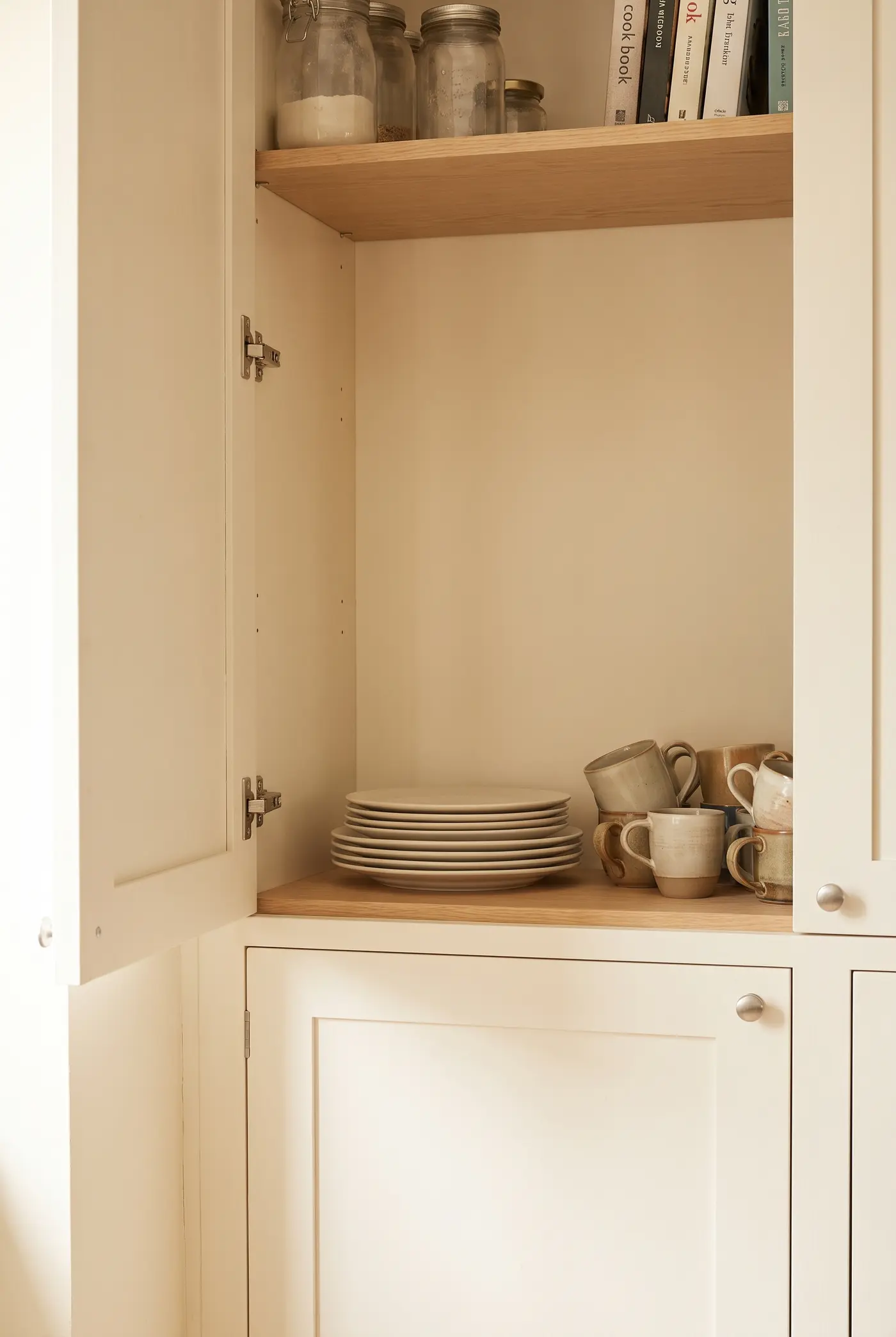Plates stacked directly on a cabinet shelf with a wide band of unused space above them